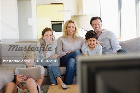 Family watching TV together at home
