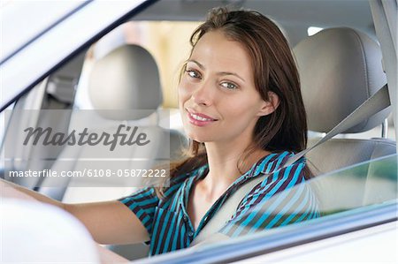 Portrait of a beautiful young woman sitting at driver's seat