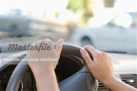 Close-up of human hand holding steering wheel