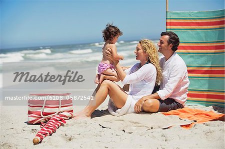 Couple playing with their daughter on the beach