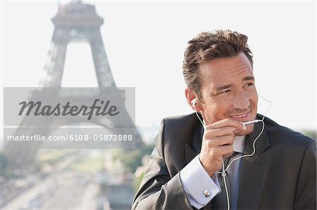 Businessman using a hands-free device with the Eiffel Tower in the background, Paris, Ile-de-France, France