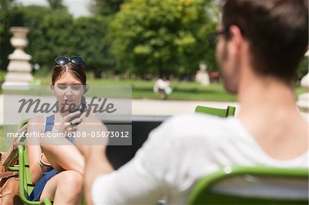 Woman text messaging with a mobile phone, Jardin des Tuileries, Paris, Ile-de-France, France