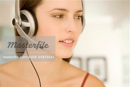 Portrait of a young woman, listening to music with headphones