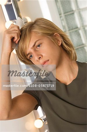 Teenage Boy Combing His Hair Stock Photo Masterfile Premium