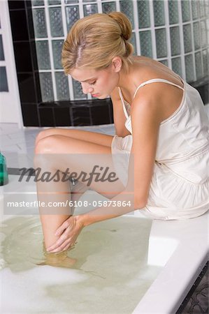 Woman soaking her legs in a bathtub