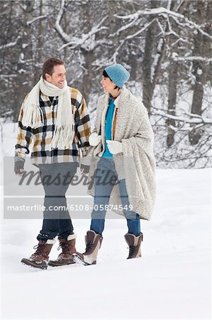 Young couple looking at each other, walking in snow
