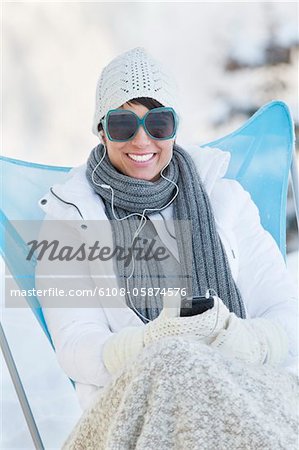 Young woman listening to MP3 player in snow