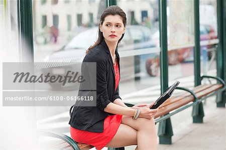 Woman sitting at a bus stop