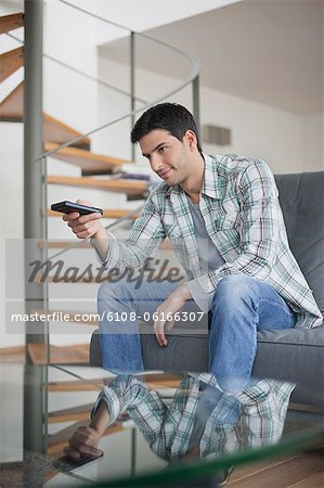 Man changing channels with a remote control