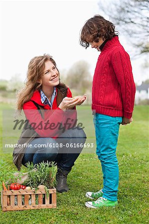 Woman showing vegetables to her son
