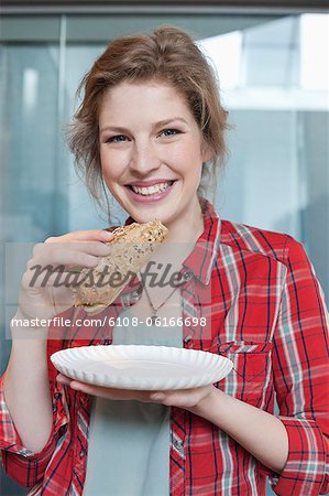 Portrait of a woman eating sandwich and smiling