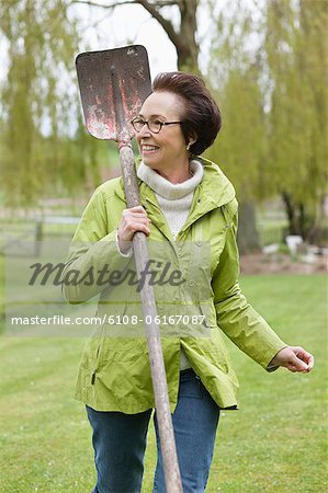 Woman walking with a spade in a park