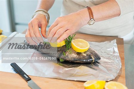 Elderly woman preparing seafood in a kitchen