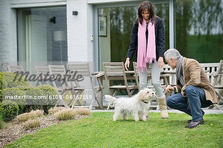 Couple playing with their pets in a garden