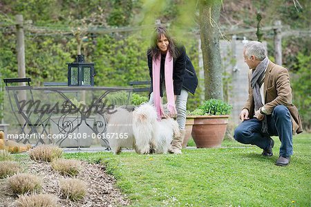 Couple playing with their pets in a garden