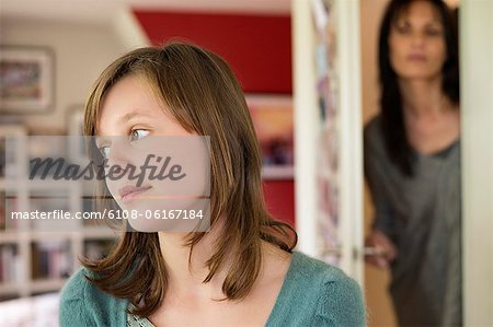 Woman watching her daughter behind the door in the bedroom