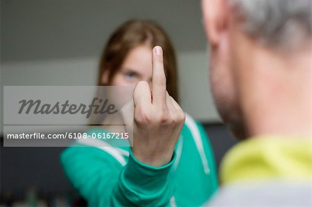 Girl showing middle finger to her father