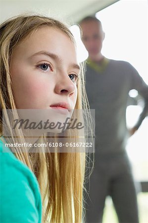 Girl looking upset with her father standing beside her