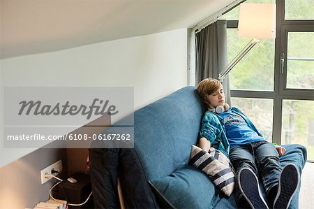 Teenage boy sleeping on a couch at home