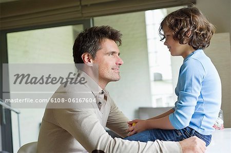 Man with his son looking at each other at home