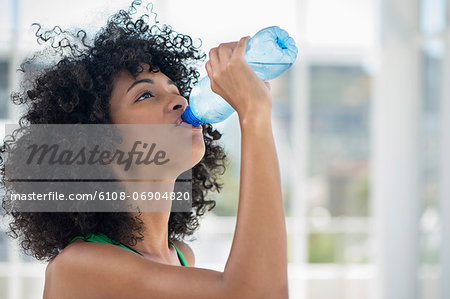 Close-up of a woman drinking water from a bottle