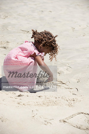 Girl playing with sand on the beach