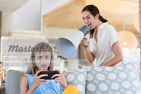 Woman shouting through a megaphone at his daughter for playing video game