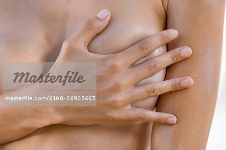 Woman hiding her breast with her hand
