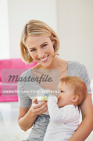 Woman feeding milk her baby with a bottle