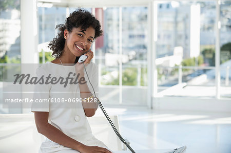 Portrait of a woman talking on a landline phone
