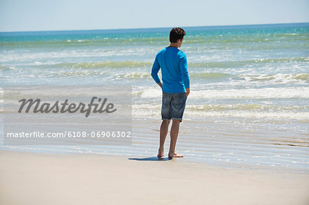 Man standing on the beach and looking at the sea