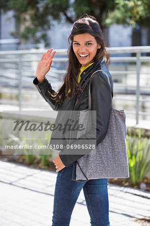 Portrait of a woman waving her hand and smiling