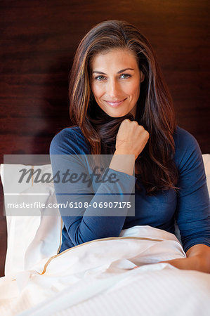 Woman smiling on the bed in a hotel room