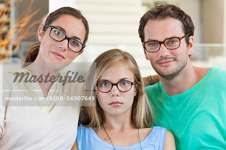 Portrait of a family sitting on a couch and wearing eyeglasses