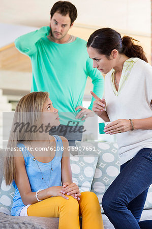 Parents scolding their daughter at home Parents scolding their daughter at home