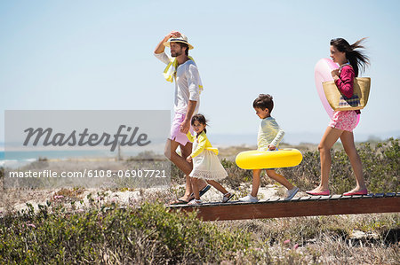 Family walking on a boardwalk on the beach