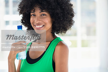 Smiling woman drinking water from a bottle