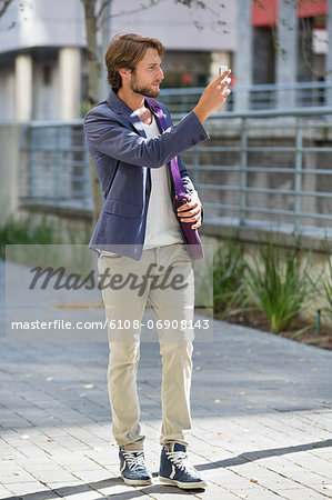 Man taking a picture with mobile phone on a street