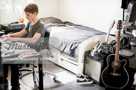 Teenage boy typing on laptop