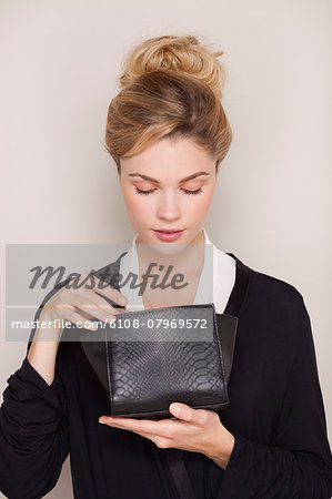 Beautiful woman checking her makeup bag