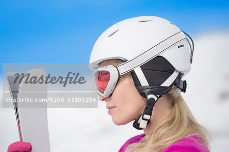 Woman holding skis in snow, Crans-Montana, Swiss Alps, Switzerland