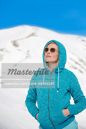 Beautiful woman standing in snow, Crans-Montana, Swiss Alps, Switzerland