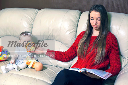 France, nanny or very new mother in the living room