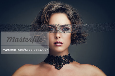 Portrait of a young woman, looking towards the lens, a lace blindfold