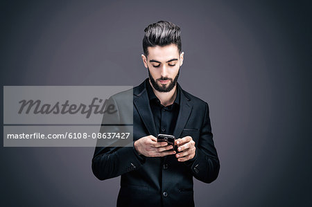 Portrait of a young businessman writing a text message