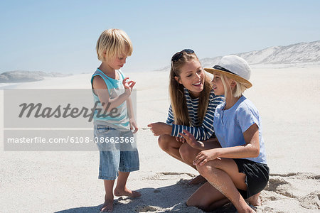 Beautiful woman enjoying on the beach with her children