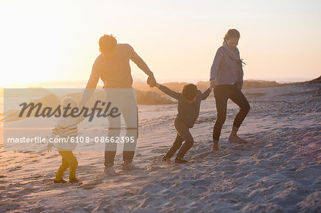 Parents with their children walking on the beach