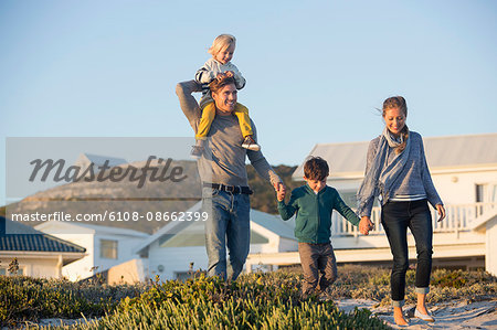 Happy couple with their children walking on the beach Happy couple with their children walking on the beach