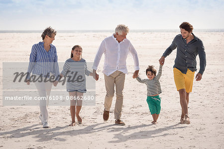Happy multi-generation family walking on beach
