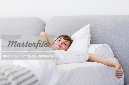 Woman waking up and yawning with a stretch